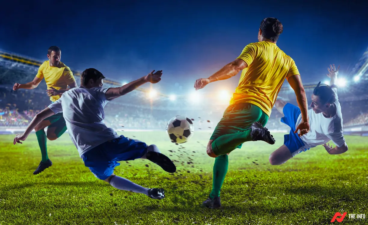 A close-up of a football player's determined face as they kick the ball.
